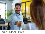 Young Caucasian businessman smiling and extending hand for a handshake in a modern office during daytime. Стоковое AI-изображение, AI-художник Sergey Grishin / Фотобанк Лори