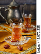 Azerbaijani black tea in armudu tea glass. Atmosphere of Baku and Eastern traditions. Oriental cuisine. Cozy atmosphere in the caucasus cafe. Стоковое фото, фотограф Андрис Салминьш / Фотобанк Лори