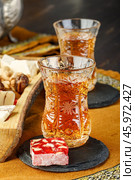 Azerbaijani black tea in armudu tea glass. Atmosphere of Baku and Eastern traditions. Oriental cuisine. Cozy atmosphere in the caucasus cafe. Стоковое фото, фотограф Андрис Салминьш / Фотобанк Лори
