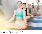 Young lady performs comfortable half-lotus pose, Ardha padmasana. Стоковое фото, фотограф Яков Филимонов / Фотобанк Лори