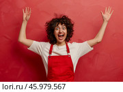 Ecstatic young woman in red apron against vibrant pink background. Стоковое AI-изображение, AI-художник Zakharova Natasha / Фотобанк Лори