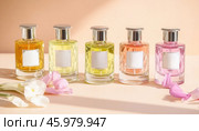 Five perfume bottles with blank labels displaying different fragrances. Стоковое AI-изображение, AI-художник Юрий Поздников / Фотобанк Лори