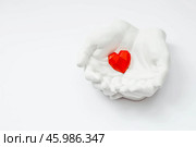 Stylish banner. In his hands, a red heart on a white background is made of plaster. World Health, Love and Insurance Day. World Heart, Health and Organ Donor Day. Стоковое фото, фотограф Photojuli / Фотобанк Лори