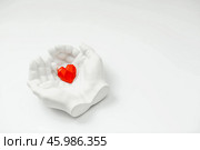 Stylish banner. In his hands, a red heart on a white background is made of plaster. World Health, Love and Insurance Day. World Heart, Health and Organ Donor Day. Стоковое фото, фотограф Photojuli / Фотобанк Лори