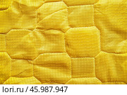 Yellow quilted fabric background showing stitching detail and texture. Стоковое AI-изображение, AI-художник Иван Рябоконь / Фотобанк Лори