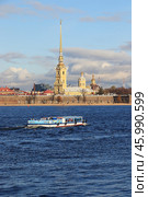 Peter and Paul Fortress.Russia, Petersburg, September 21, 2018,  On the photo is Peter and Paul Fortress and a tourist boat sailing along the Neu River. The fortress was laid down on May 16 (27), 1703, according to a joint plan of Peter I and French engineer Lambert: 6 bastions connected by curtains , 2 Ravelina, Kronverk (originally tree-earthen, in the 1730s-1740s and 1780s dressed as stones). Редакционное фото, фотограф Светлана Балынь / Фотобанк Лори