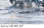 High speed vehicle splashing water while driving through roadside puddle, generating dramatic spray pattern. Стоковое фото, фотограф Mikhail Davidovich / Фотобанк Лори
