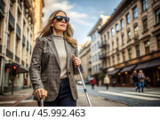 Disability. Loss of vision. A blind woman with a cane and sunglasses is walking down a city street. International Day of the Blind on November 13. Стоковое AI-изображение, AI-художник Photojuli / Фотобанк Лори