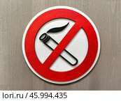 Close up of no smoking sign displayed on a wooden wall emphasizing the importance of a smoke-free environment. Стоковое фото, фотограф Александра Селина / Фотобанк Лори