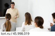 Male trainer near interactive board conducting advanced training courses to office employees sitting at desks in auditory. Стоковое фото, фотограф Яков Филимонов / Фотобанк Лори