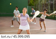 Sporty woman performing basic strokes during paleta fronton group training. Стоковое фото, фотограф Яков Филимонов / Фотобанк Лори