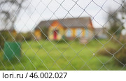 Chain link fence detail, blurring residential building behind, symbolizing boundary, privacy, protection of residential space. Стоковое видео, видеограф Mikhail Davidovich / Фотобанк Лори