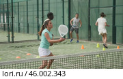 Sporty woman and other athletes training on the tennis court. Стоковое видео, видеограф Яков Филимонов / Фотобанк Лори
