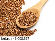 buckwheat groats and wooden spoon on white background. Стоковое фото, фотограф Сергей Толмачёв / Фотобанк Лори