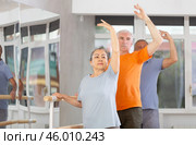 Elderly women and men practice at ballet standing in fourth position at barre in choreography studio. Стоковое фото, фотограф Яков Филимонов / Фотобанк Лори