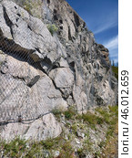 Metal protecting net on mountain stone slope in Altai. Metal mesh to prevent rockfall on road. Стоковое фото, фотограф Сергей Пристяжнюк (Serg Zastavkin) / Фотобанк Лори