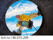 Bottom view of man immersing sewage pump into septic tank. Стоковое фото, фотограф Владимир Григорьев / Фотобанк Лори