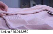 A woman is reviewing a knitted set. A knitted sweater and skirt. She is laying out the clothes on the table. Close-up. Стоковое видео, видеограф Vadzim Yakubovich / Фотобанк Лори