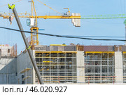 Строящееся высотное здание и подъемный кран на фоне голубого неба. Building crane and building under construction against blue sky. Стоковое фото, фотограф Татьяна Д / Фотобанк Лори