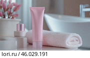 Blank cosmetic plastic pink tube mockup. Cream lotion gel packaging, white bathroom towel stack. Skincare beauty product. Marketing branding template mock up. Empty brand design background. Self care. Стоковое AI-видео, аниматор Марина Демидюк / Фотобанк Лори