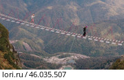Extreme mountain activities in the Sochi area. Tourists walk across a suspension bridge at a dizzying height. Экстремальные виды активного отдыха в горах в окрестностях Сочи. Туристы проходят по подвесному мосту на головокружительной высоте. Редакционное видео, видеограф Валерий Тесаков / Фотобанк Лори