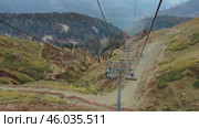 The ski lift, which tourists use to reach the peaks, offers a spectacular autumn landscape. Осенний пейзаж, снятый с горнолыжного подъемника, которым туристы пользуются, чтобы подняться на вершины. Редакционное видео, видеограф Валерий Тесаков / Фотобанк Лори