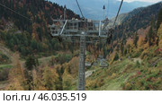 Active recreation in the mountains during autumn. Taking a scenic panoramic view from a ski lift. Активный отдых в горах осенью. Съёмка живописной панорамы с горнолыжного подъёмника. Редакционное видео, видеограф Валерий Тесаков / Фотобанк Лори