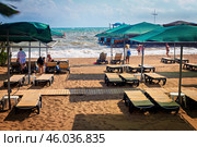 Пляж с шезлонгами и навесами на фоне штормящего моря. Редакционное фото, фотограф Владимир Шипикин / Фотобанк Лори