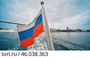 Russian flag waving from boat sailing in the eastern golden horn bay, near the zolotoy rog bridge in vladivostok, russia. Стоковое фото, фотограф Mikhail Davidovich / Фотобанк Лори