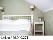 A bed with white sheets and a vintage Provence-style bedside table in a hotel room or a home bedroom. Space for the text. Enjoying the morning concept. Стоковое фото, фотограф Photojuli / Фотобанк Лори