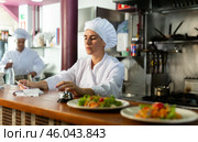 Female cook reads the paid check and presses the bell for the waiter in restaurant. Стоковое фото, фотограф Яков Филимонов / Фотобанк Лори