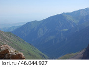 Горы, скалы ледники, аллювиальные осыпи и вершины Заилийского Алатау, район горнолыжного комплекса Чимбулак (Шимбулак), туристический маршрут на вершину, Альпинист на фоне скал. Rocks, glaciers and peaks of the Zailiyskiy Alatau, the area of ​​the Chimbulak (Shimbulak) ski resort, a tourist route to the top, a climber against the backdrop of rocks. Стоковое фото, фотограф Юрий Карачев / Фотобанк Лори