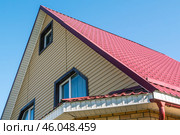 A newly built two-storey house with a metal roof.  The roof is made of metal tiles. Protection of the house from atmospheric precipitation. Стоковое фото, фотограф Эдуард Белкин / Фотобанк Лори
