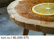 Lemon slice resting on varnished wood slab coffee table. Стоковое AI-изображение, AI-художник Иван Рябоконь / Фотобанк Лори