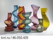 Colorful glass vases standing on white surface, modern art and design. Стоковое AI-изображение, AI-художник Иван Рябоконь / Фотобанк Лори