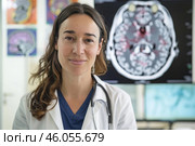 Neurologist smiling with brain scan in the background. Стоковое AI-изображение, AI-художник Иван Рябоконь / Фотобанк Лори
