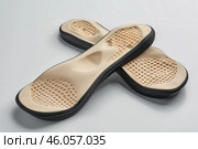 Pair of modern orthopaedic shoe insoles on white background. Стоковое AI-изображение, AI-художник Иван Рябоконь / Фотобанк Лори