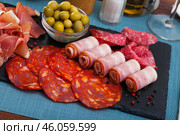 Slices of gammon, chorizo, salami, bacon on slate board. Стоковое фото, фотограф Яков Филимонов / Фотобанк Лори