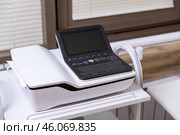 Electrocardiogram equipment for making cardiogram test of patient who is attached with vacuum sensors to the machine near coach in medical office room. Healthcare concept. Стоковое фото, фотограф Ирина Михайличенко / Фотобанк Лори