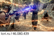 Group of friends paintball players of opposite teams in shootout in forest. Стоковое фото, фотограф Яков Филимонов / Фотобанк Лори