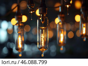 Group of vintage edison light bulbs is hanging and glowing in the dark. Стоковое AI-изображение, AI-художник Иван Рябоконь / Фотобанк Лори