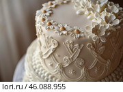 Detail of wedding cake decorated with white fondant and flowers. Стоковое AI-изображение, AI-художник Иван Рябоконь / Фотобанк Лори