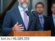Close up of senior man giving speech from a tribune. Стоковое AI-изображение, AI-художник Евгений Харитонов / Фотобанк Лори