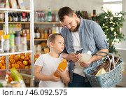 Man with preteen son scanning barcode on drink bottles in grocery store. Стоковое фото, фотограф Яков Филимонов / Фотобанк Лори