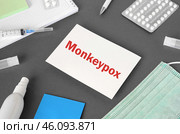 The word Monkeypox on Gray modern doctor desk table background. Mask, notepad, syringe, sanitizer and supplies. Monkeypox spreading. Medicine and healthcare, medical education. Top view. Стоковое фото, фотограф Марина Демидюк / Фотобанк Лори
