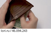 Personal savings. A man carefully puts a dollar in an empty wallet. Стоковое видео, видеограф Владимир Федоров / Фотобанк Лори