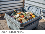 An open compost container with peels and fruit and vegetable clippings. Organic waste in a garden composter. Eco-friendly gardening, sustainability, ecology. Стоковое AI-изображение, AI-художник Photojuli / Фотобанк Лори