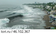 tsunami storm waves crash onto the shore of a residential area filled with apartment buildings, causing destruction, aerial view. Стоковое AI-видео, аниматор Александр Довянский / Фотобанк Лори