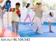Boy hitting the focus mitts held by his boxing trainer in gym. Стоковое фото, фотограф Яков Филимонов / Фотобанк Лори