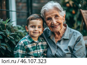A happy family, a child and a grandmother hug on the street in the park, happy and contented. A grandmother who hugs her grandson, showing love. Стоковое AI-изображение, AI-художник Photojuli / Фотобанк Лори